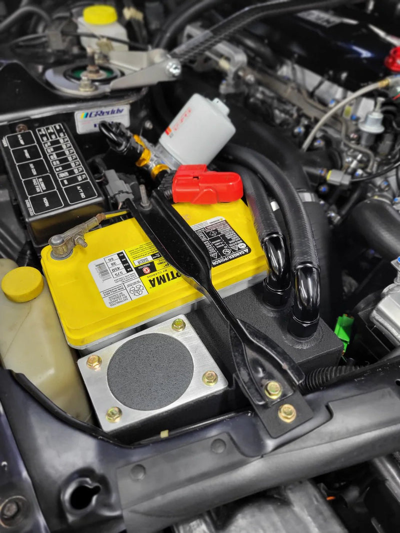 Load image into Gallery viewer, Black oil catch can system installed in a Nissan R32 GTR engine bay next to a yellow Optima battery.