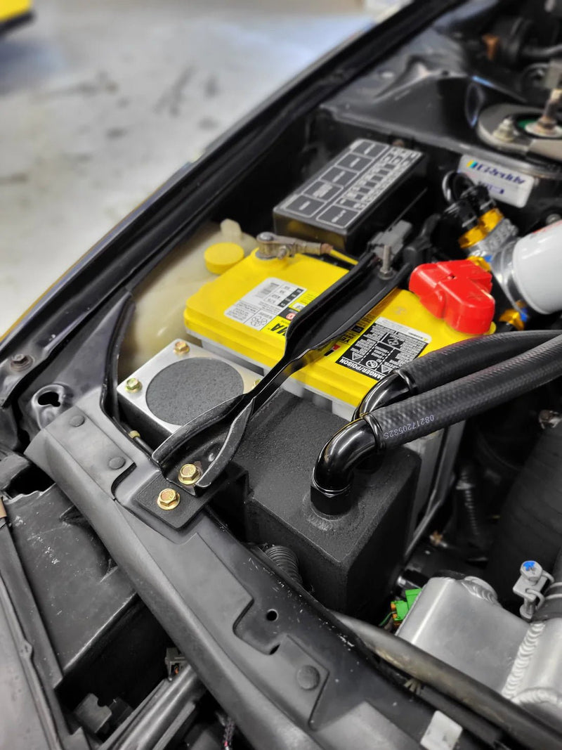 Load image into Gallery viewer, Black catch can oil separator system installed in a Nissan R32 GTR engine bay next to a yellow battery.