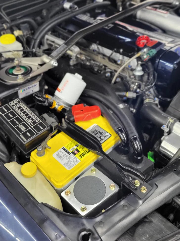 Load image into Gallery viewer, SynGarage oil catch can/separator installed in a Nissan R32 GTR engine bay with a yellow Optima battery.