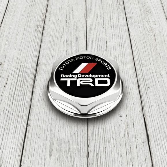 ギャラリービューアに画像をロードする, Genuine Toyota TRD oil cap for MK4 Supra. Features a metallic silver finish with a black and red TRD logo face.