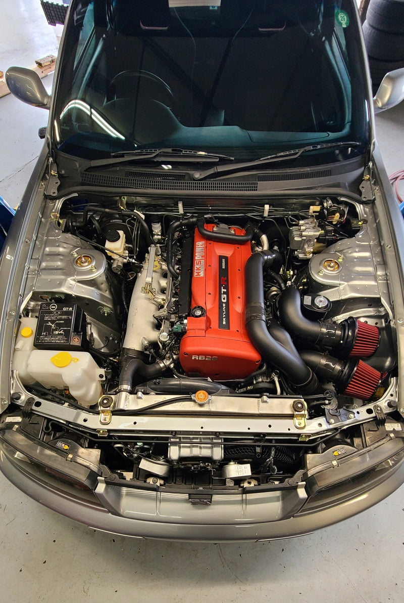 Load image into Gallery viewer, U.P.G. piping package installed in an R33/R34 engine bay, featuring black piping and red intake filters.