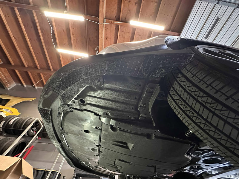 Load image into Gallery viewer, Black front lip installed on a Toyota Corolla Hatchback (E210, 2023+ Kouki), viewed from underneath the vehicle.