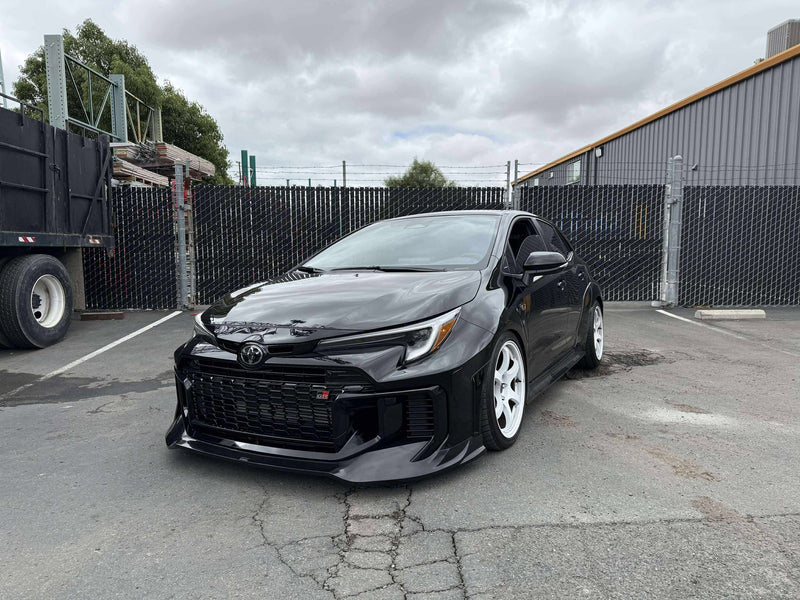 Load image into Gallery viewer, Gloss black front lip on a black 2025 Toyota GR Corolla E210 (Kouki) with white wheels.