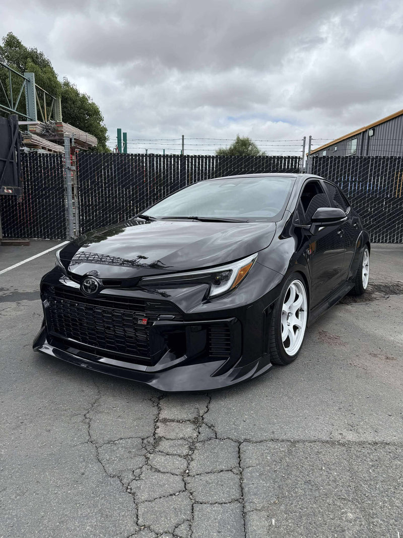 Load image into Gallery viewer, Gloss black front lip installed on a 2025+ Toyota GR Corolla (E210 Kouki) with white wheels.