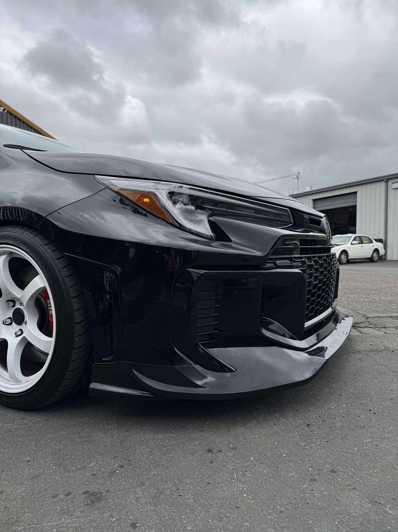 Load image into Gallery viewer, Glossy black front lip installed on a 2025+ Toyota GR Corolla (E210 Kouki) with white wheels.