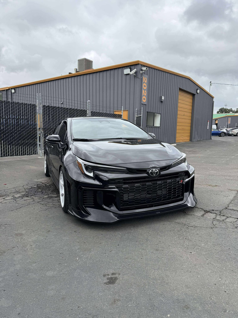 Load image into Gallery viewer, Gloss black front lip installed on a 2025+ Toyota GR Corolla (E210, Kouki) parked in a lot.