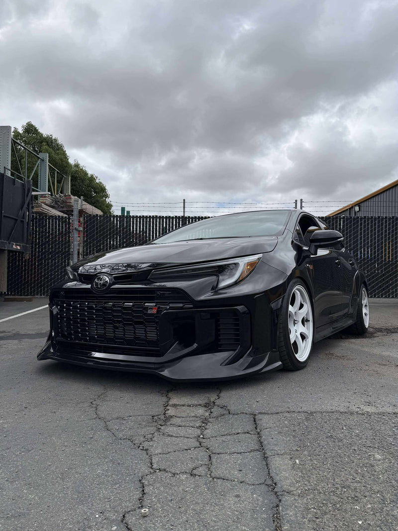 Load image into Gallery viewer, Gloss black front lip installed on a 2025+ Toyota GR Corolla (E210) with white wheels.