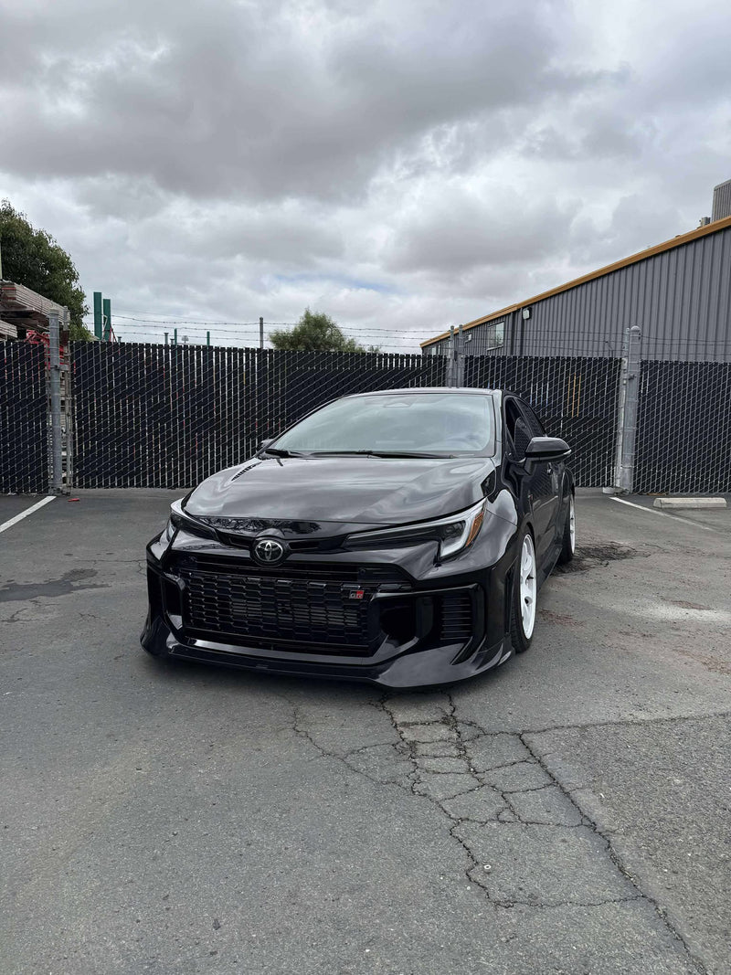 Load image into Gallery viewer, Gloss black front lip on a 2025+ Toyota GR Corolla (E210, Kouki) parked in a lot.