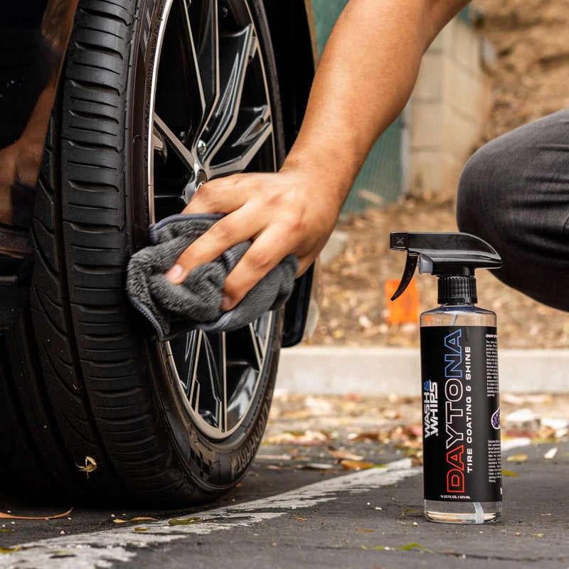 ギャラリービューアに画像をロードする, Person using a gray microfiber cloth to wipe a clean black alloy wheel and tire with Wash & Whips Daytona spray.