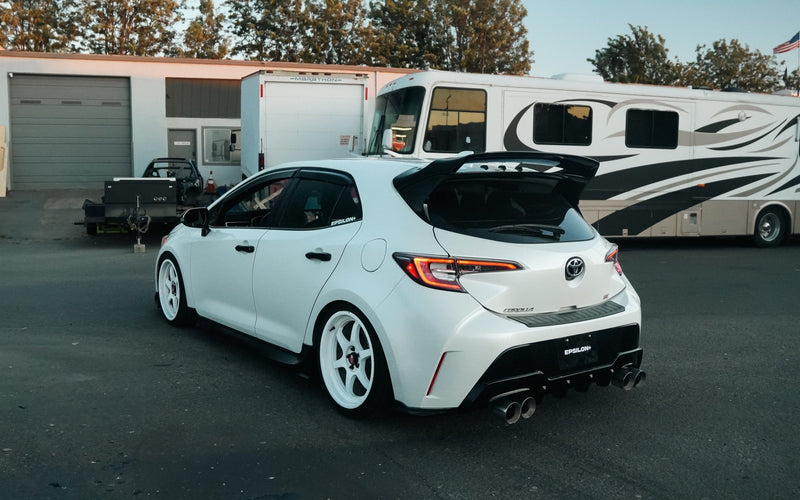 Load image into Gallery viewer, Gloss black rear spats on a white Toyota Corolla Hatchback (E210, 2019+).