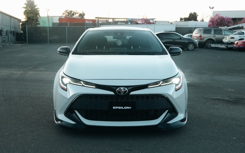 Load image into Gallery viewer, Black front lip installed on a white Toyota Corolla Hatchback (E210, 2019-2022 Zenki).