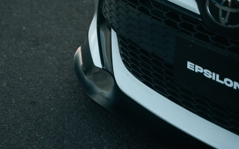 Load image into Gallery viewer, Black front lip for Toyota Corolla E210 (2019-2022) hatchback installed on a white front bumper.