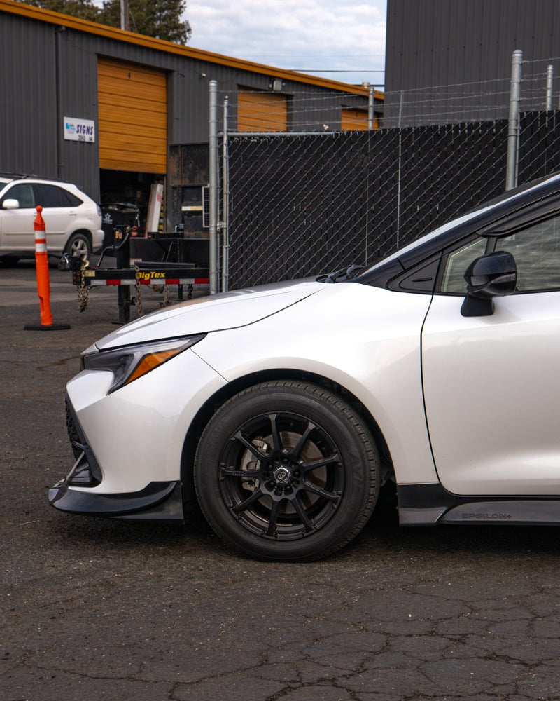 Load image into Gallery viewer, Gloss black front lip installed on a white 2023+ Toyota Corolla Hatchback (E210 Kouki).