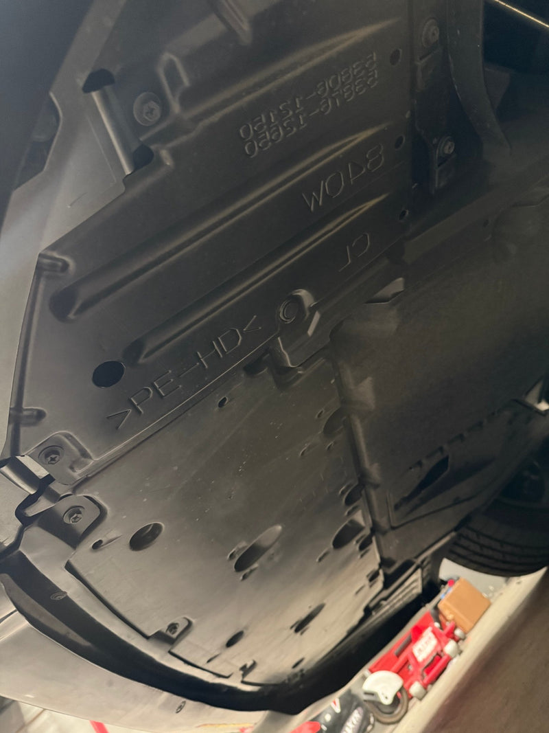 Load image into Gallery viewer, Black plastic front lip undercarriage for 2025+ Toyota GR Corolla (E210, Kouki) showing factory part numbers and stamps.