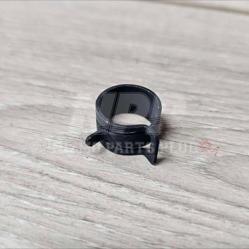 Load image into Gallery viewer, Black spring-style oil cooler hose clamp for Nissan RB26DETT (R32/R33/R34), in new condition.