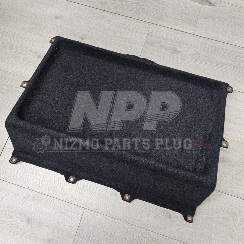 ギャラリービューアに画像をロードする, Black Nissan Z32 300ZX 2+0 rear parcel shelf finisher with mounting tabs, shown on a wood floor.
