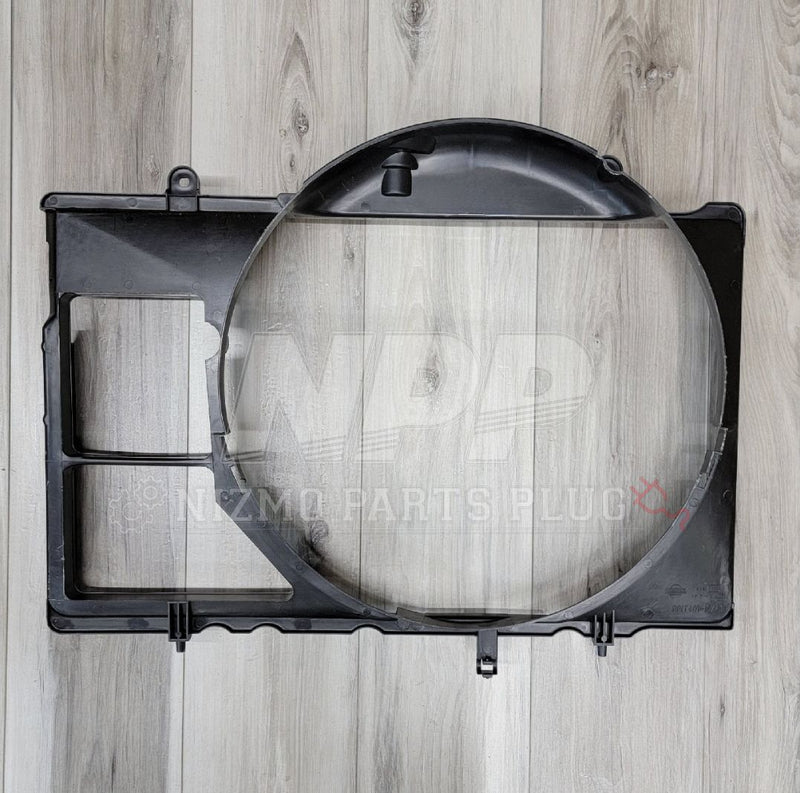Load image into Gallery viewer, Black Nissan R34 Skyline GTT radiator fan shroud in good condition on a wood grain background.