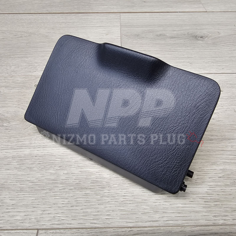 Load image into Gallery viewer, Black Nissan R34 Skyline fuse block lid with textured finish, shown from an overhead angle on a wood surface.