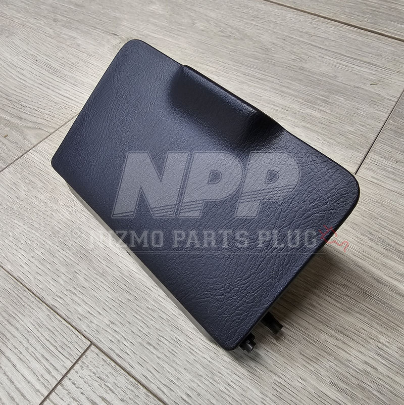 Load image into Gallery viewer, Black Nissan R34 Skyline fuse block lid with textured finish, positioned on a light wooden floor.