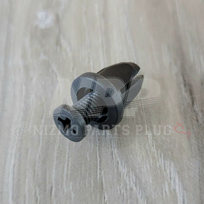 Load image into Gallery viewer, New black Nissan OEM door sill push clip fastener for Skyline R32, R33, R34 models on a wood-grain background.