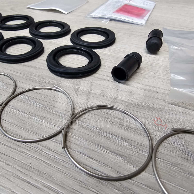 Load image into Gallery viewer, Nissan R34 Skyline GTT Rear Caliper Seal Rebuild Kit - NizmoPartsPlug
