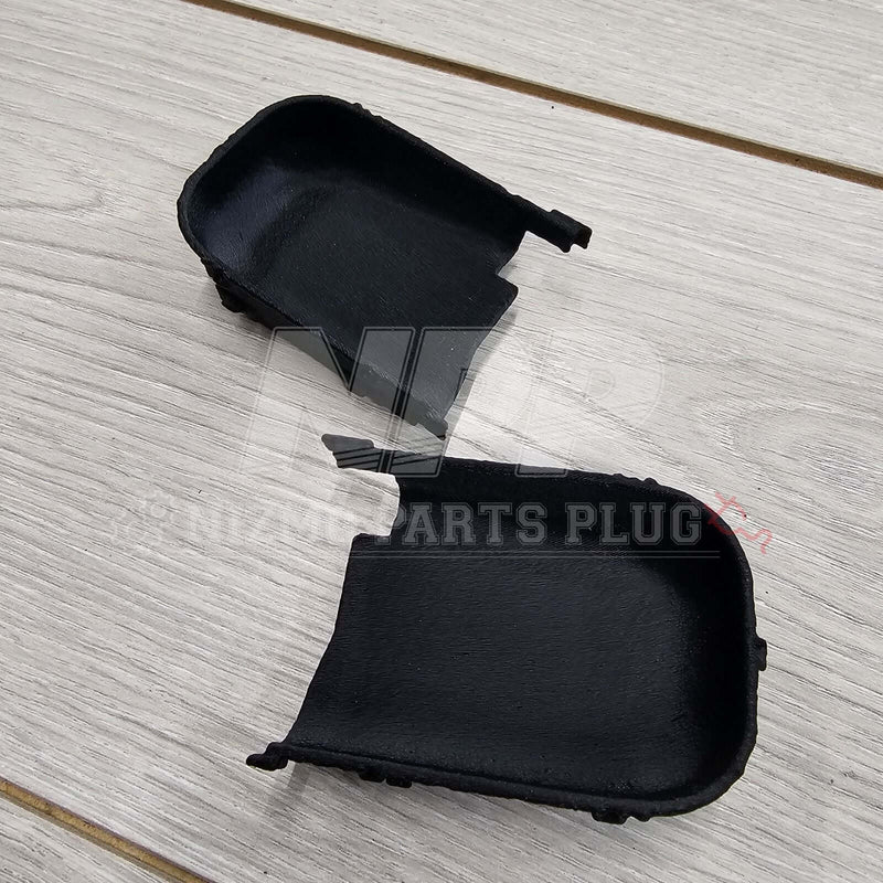 Load image into Gallery viewer, Pair of black interior door handle covers for Nissan Skyline R34, viewed from the textured back side.