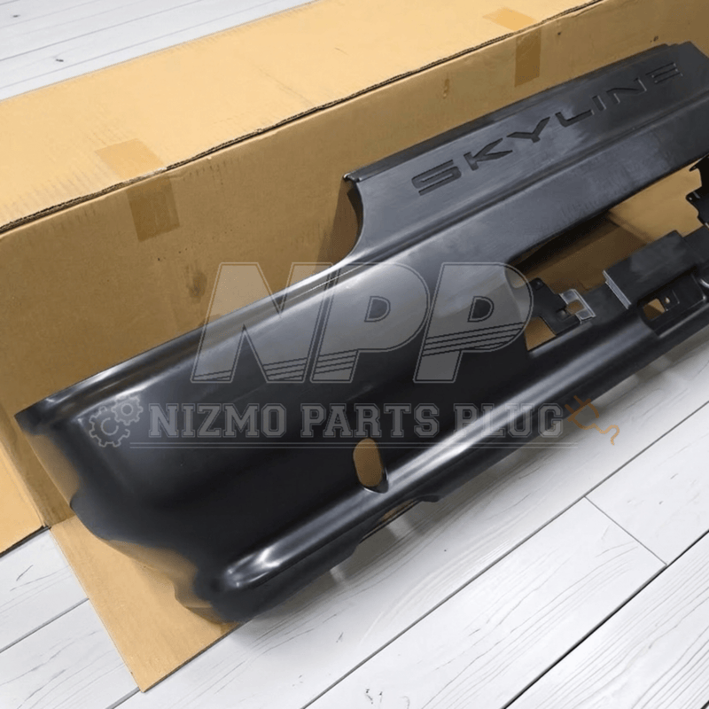 Load image into Gallery viewer, Black Nissan R32 Skyline GTR rear bumper assembly with embossed "SKYLINE" lettering on a cardboard background.