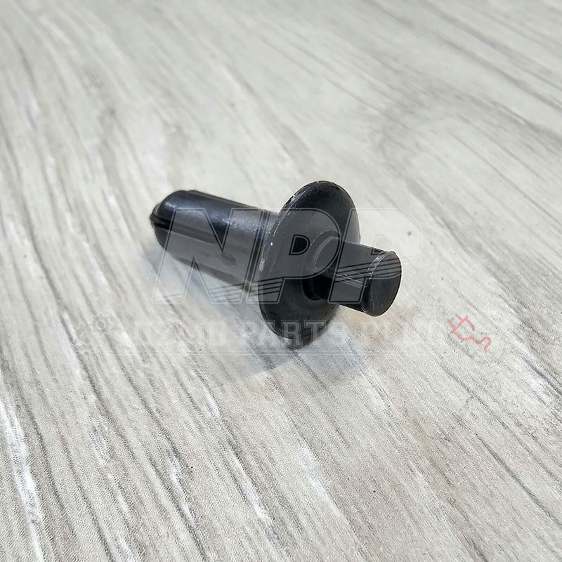 Load image into Gallery viewer, Black plastic door panel push mounting clip for Nissan R34 Skyline on a light wood grain surface.