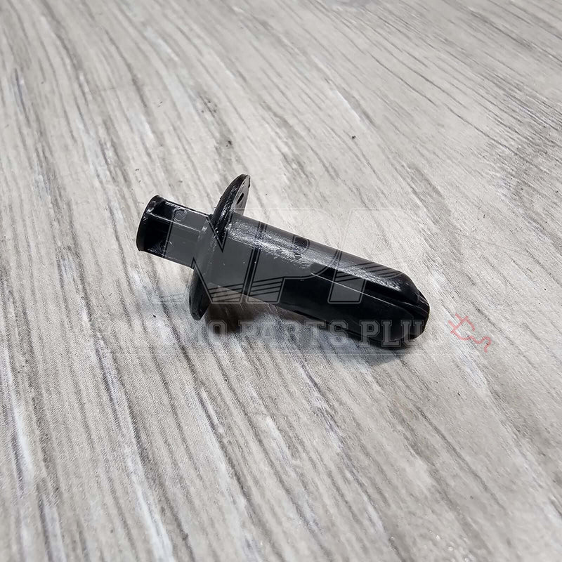Load image into Gallery viewer, Black Nissan R34 Skyline interior door panel push mounting clip on a wood grain surface.