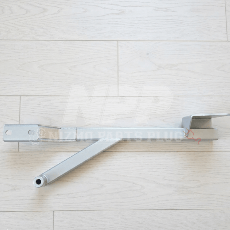 Load image into Gallery viewer, Silver Nismo BNR34 GTR center floor reinforcement bar assembly on a light wood background.