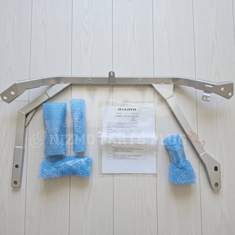 Load image into Gallery viewer, Silver Nismo front floor reinforcement bar for BNR34 GTR with instruction manual and blue bubble-wrapped hardware.