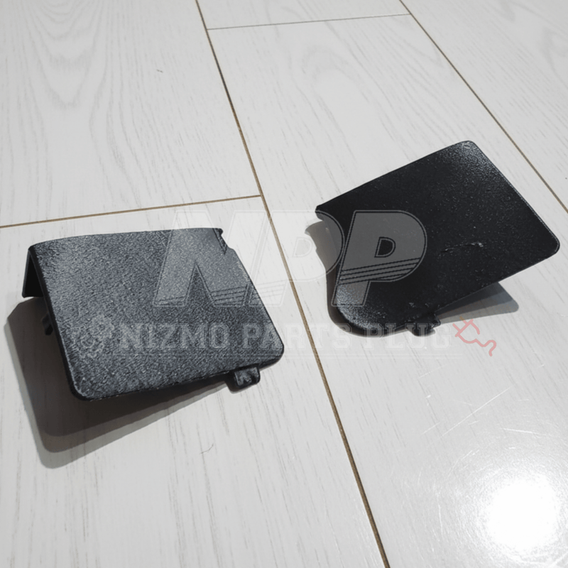 Load image into Gallery viewer, Two black Mirai Mamoru steering wheel access covers for Nissan R34 Skyline and S15 Silvia on a white floor.