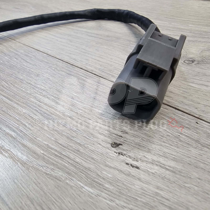 Load image into Gallery viewer, Grey O2 oxygen sensor for Nissan R33/R34 Skyline GTR with black wiring harness on a wood background.