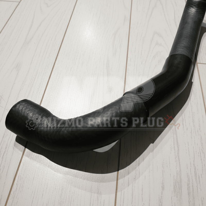 Load image into Gallery viewer, Black, curved lower radiator coolant hose for Nissan R34 Skyline GTR on a light wood floor.