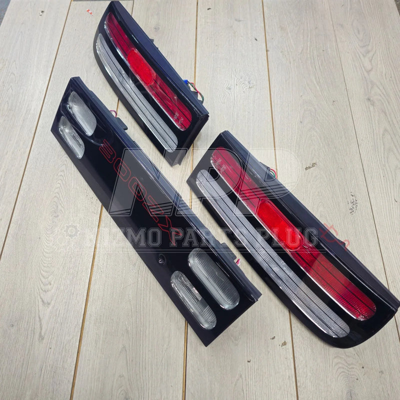 Load image into Gallery viewer, Nissan 300ZX Z32 tail lights set on light wooden floor, red and clear lens design