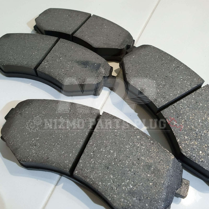 Load image into Gallery viewer, New OEM front brake pad set for Nissan S14 240SX. Grey metallic friction material on black backing plates.