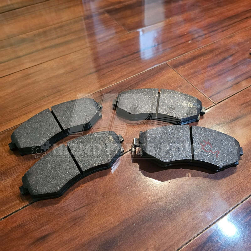 Load image into Gallery viewer, New Nissan S14 240SX front brake pad set in grey, laid out on a wooden floor.