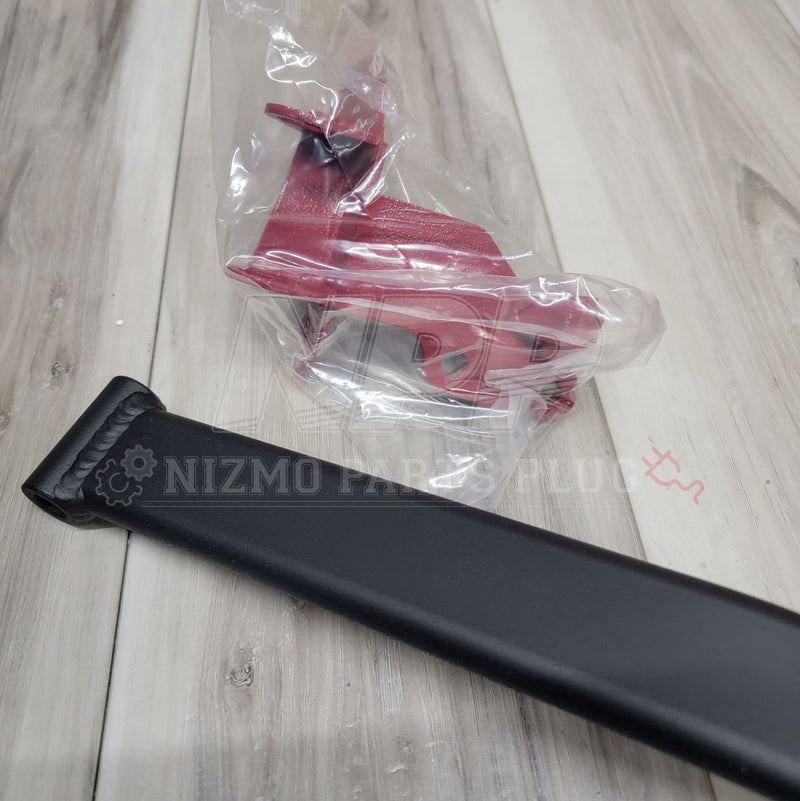 ギャラリービューアに画像をロードする, Nismo R33/R34 Skyline front strut brace in black and a red brake master cylinder stopper in plastic packaging.