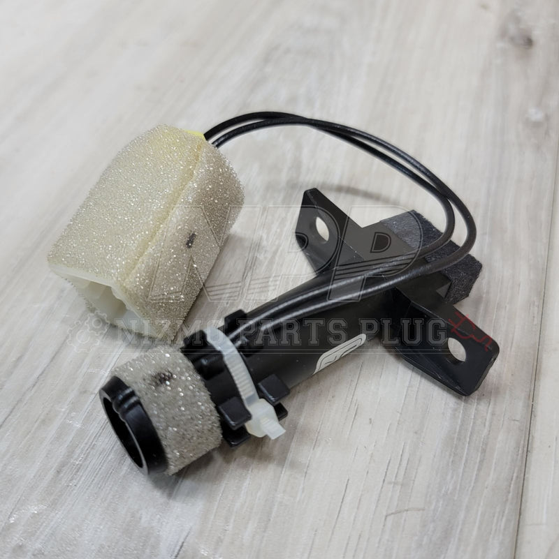 Load image into Gallery viewer, Nissan R32 Skyline AC in-car temperature sensor with black plastic body, mounting brackets, and yellowed foam insulation.
