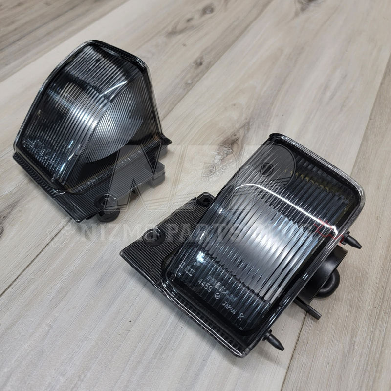 Load image into Gallery viewer, Pair of clear-lens reverse light assemblies for Nissan R32 Skyline Coupe, in excellent condition.
