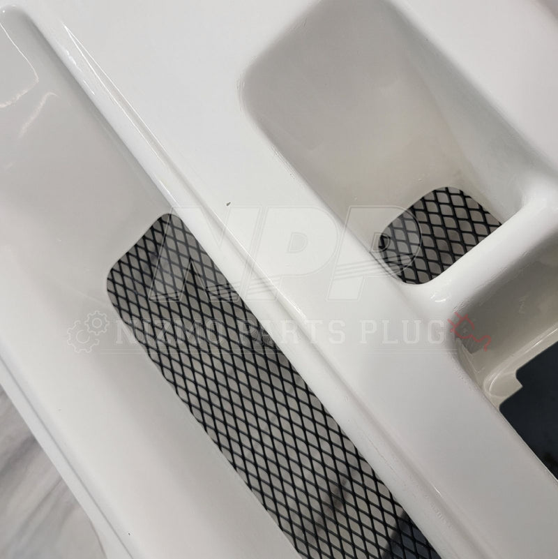 Load image into Gallery viewer, White Nissan R34 GTR Nismo S-Tune front bumper with black mesh grille inserts.
