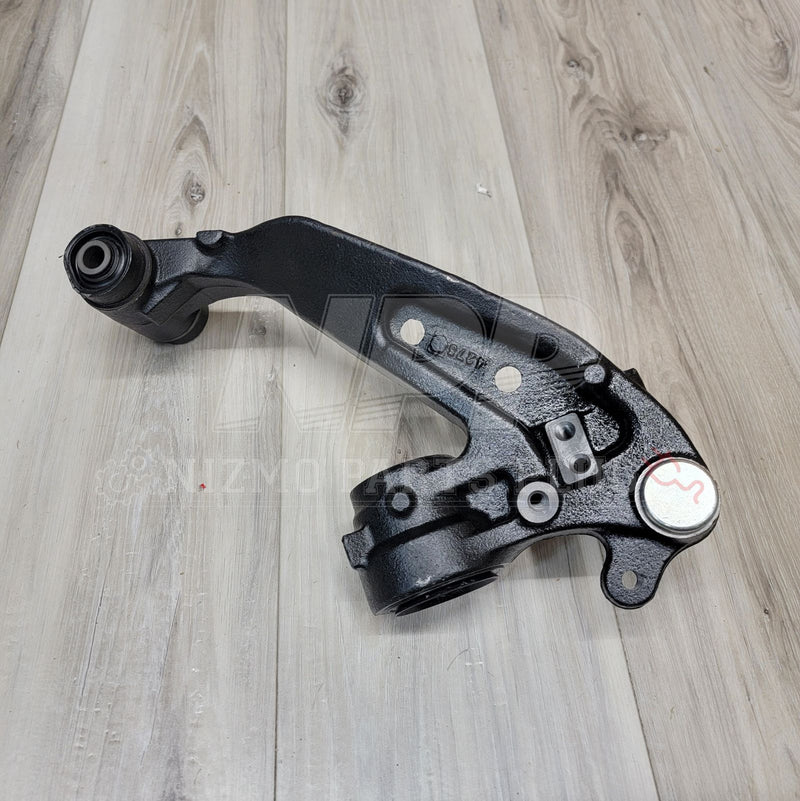 Load image into Gallery viewer, Black Nissan R33/R34 GTR front extension knuckle arm in good condition on a wood background.