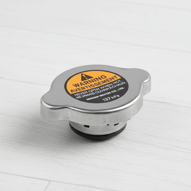 Load image into Gallery viewer, Nissan Radiator Cap on White Wood Floor