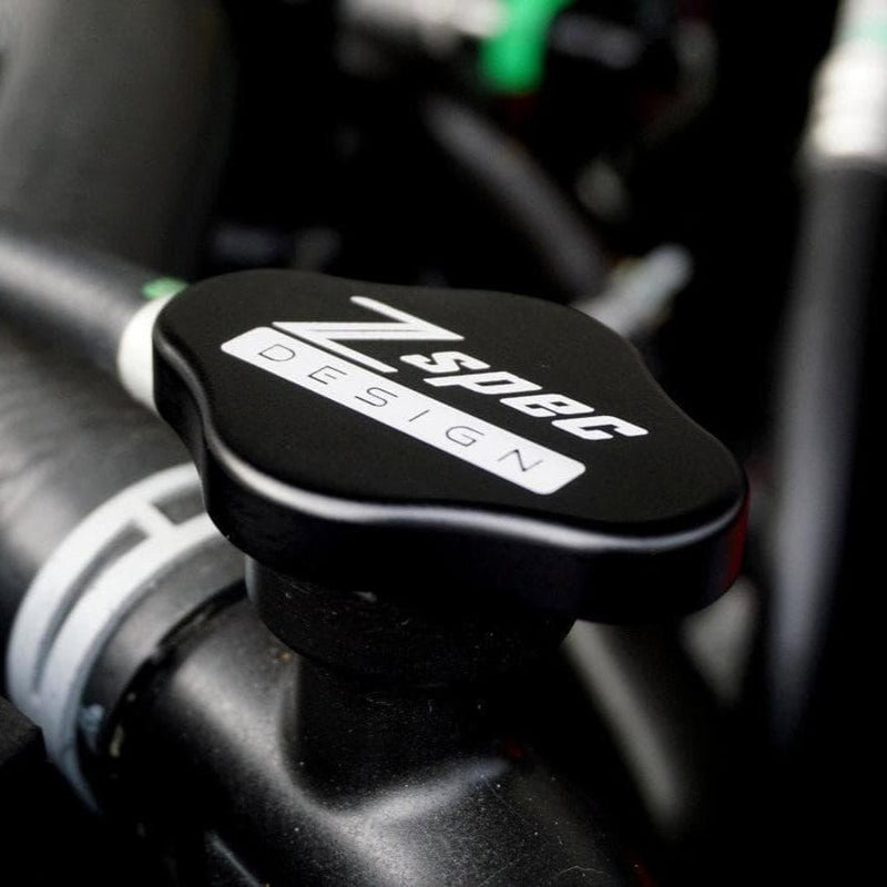 Load image into Gallery viewer, Black ZSPEC billet radiator cap cover for Nissan GT-R R32, R33, R34, and R35 installed in engine bay.