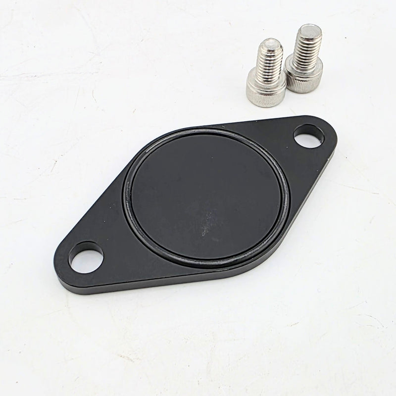 Load image into Gallery viewer, Black anodized aluminum 2JZ IACV block off plate with two mounting bolts.