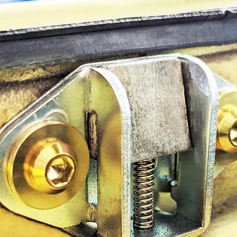 Load image into Gallery viewer, Gold-colored ZSPEC titanium fastener kit installed on a Datsun S30 trunk latch mechanism.