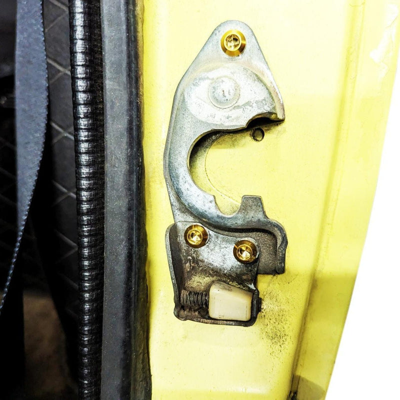 Load image into Gallery viewer, ZSPEC titanium fastener kit installed on a Datsun S30 door latch, featuring three gold-colored bolts.