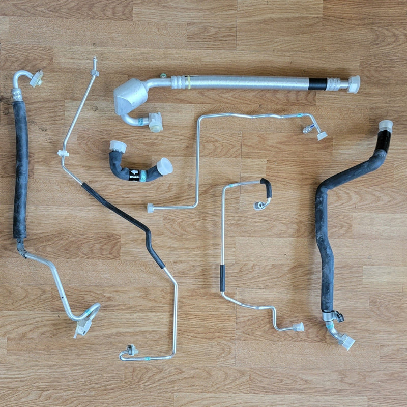 Load image into Gallery viewer, N.O.S. R134A A/C installation kit for Nissan S13 240SX, featuring various metallic lines and rubber hoses.