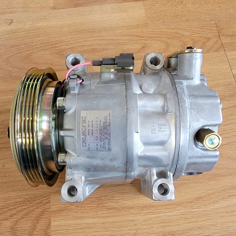 Load image into Gallery viewer, New old stock Calsonic silver R134A A/C compressor for Nissan S13 240SX with gold-toned pulley.