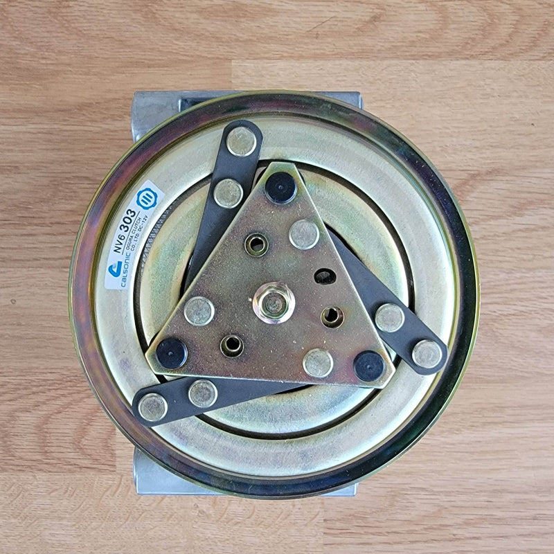 Load image into Gallery viewer, New old stock Calsonic AC compressor clutch for Nissan S13, featuring a gold-toned finish.